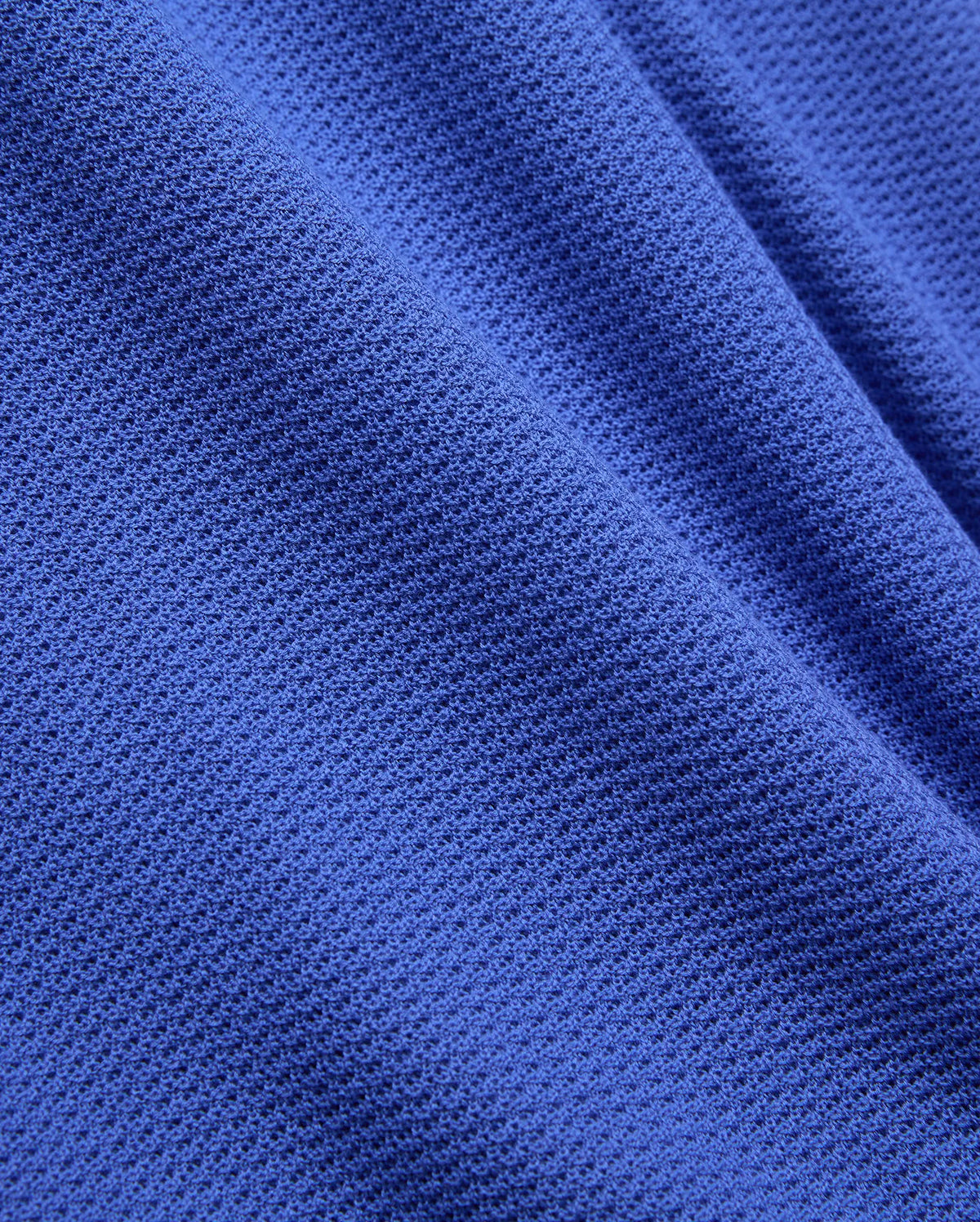 Mens Innis Polo crafted from premium, vibrant royal blue pique knit fabric, featuring a distinct, breathable texture and subtle, luxurious drape, reflecting Psycho Bunny's refined streetwear aesthetic.