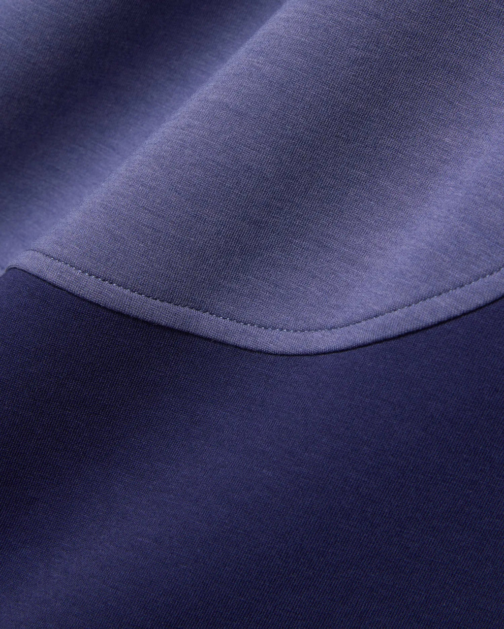 Mens Kelly Oversized Polo in dark navy and periwinkle blue color-block pique knit fabric, featuring a curved seam with visible stitching.