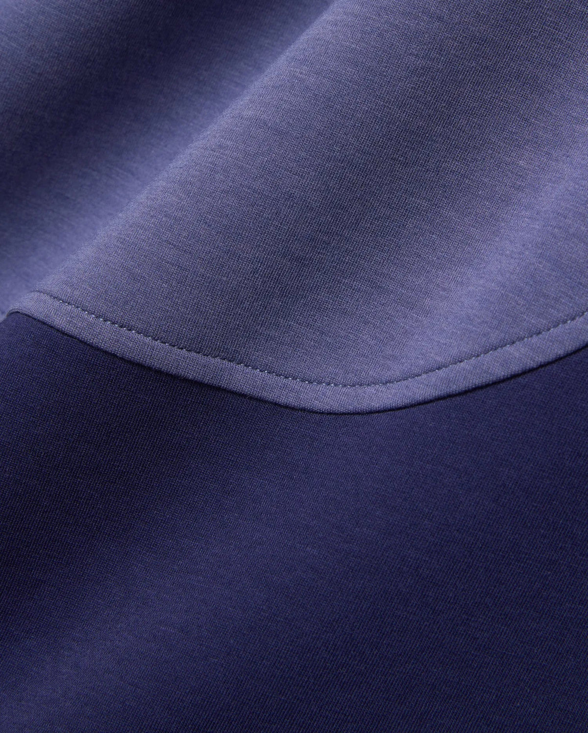 Mens Kelly Oversized Polo in dark navy and periwinkle blue color-block pique knit fabric, featuring a curved seam with visible stitching.